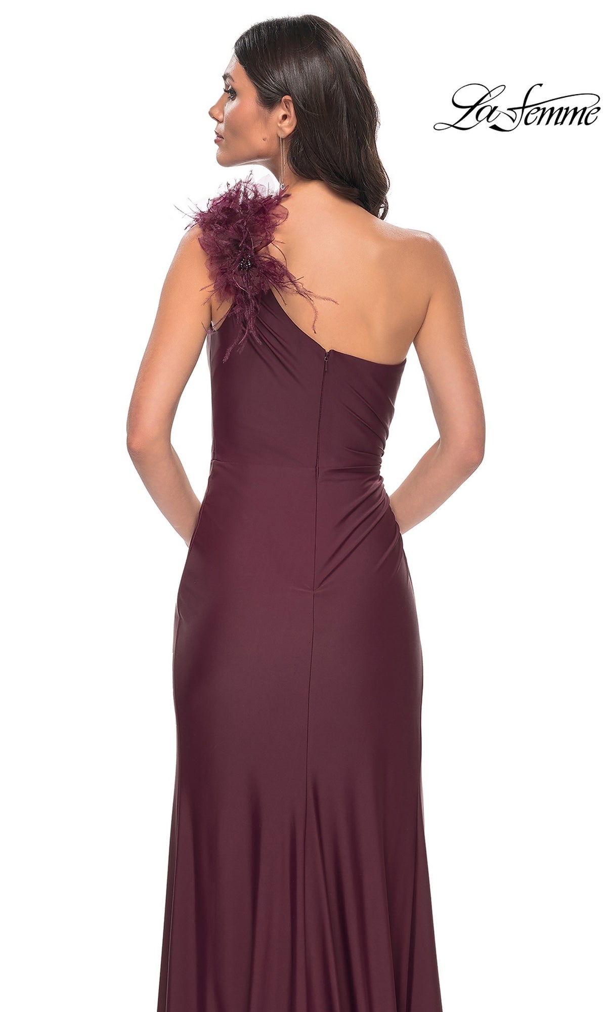 Woman wearing the La Femme Feathered One-Shoulder Prom Dress 32076 in burgundy, featuring a one-shoulder silhouette with feather and embellishment detail on the shoulder, shown from the back.